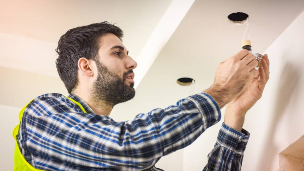 a male electrician installing LED lights 