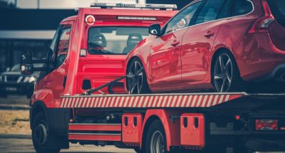 A truck towing a red car - car towing cost