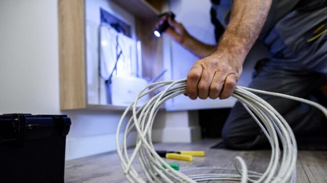 an electrical with a flashlight installing ethernet cables