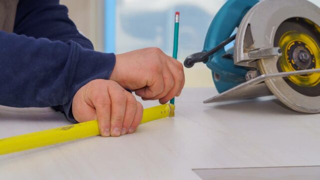 a man measuring and marking the sections