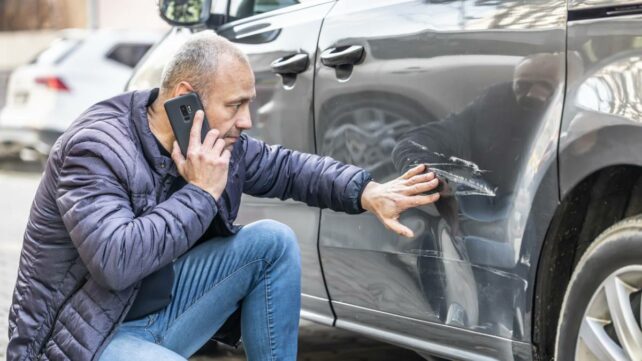 a man with a dented car panel beating cost