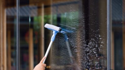 a cleaner cleaning a window - window cleaning cost